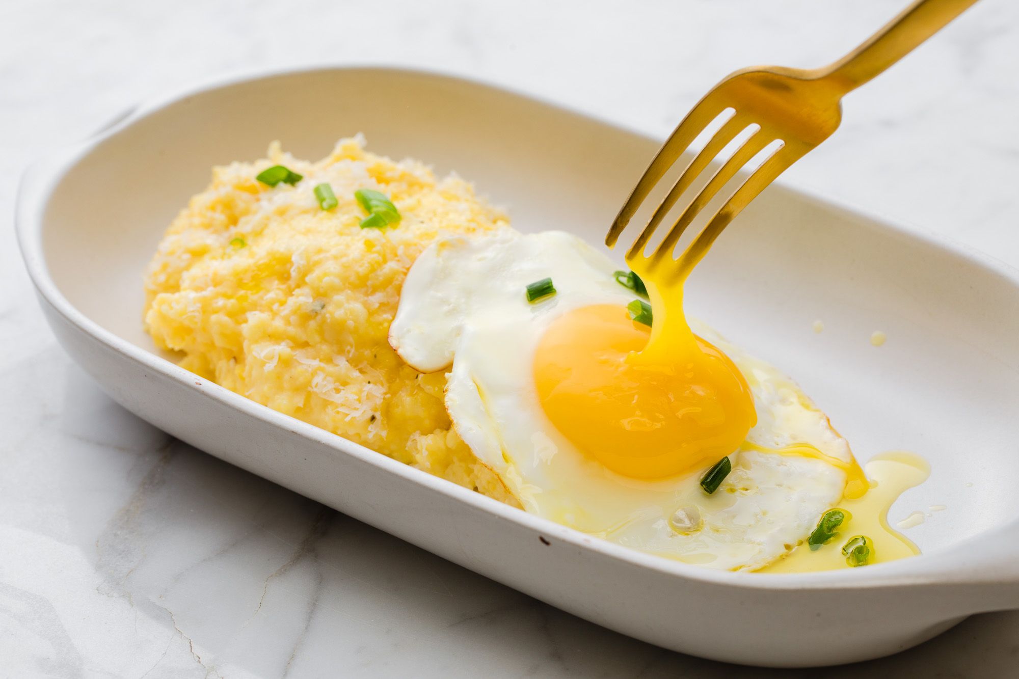 A plate of fried eggs over polenta cooked with Bertolli extra virgin olive oil. Easy Cooking recipes with olive oil. Bertolli